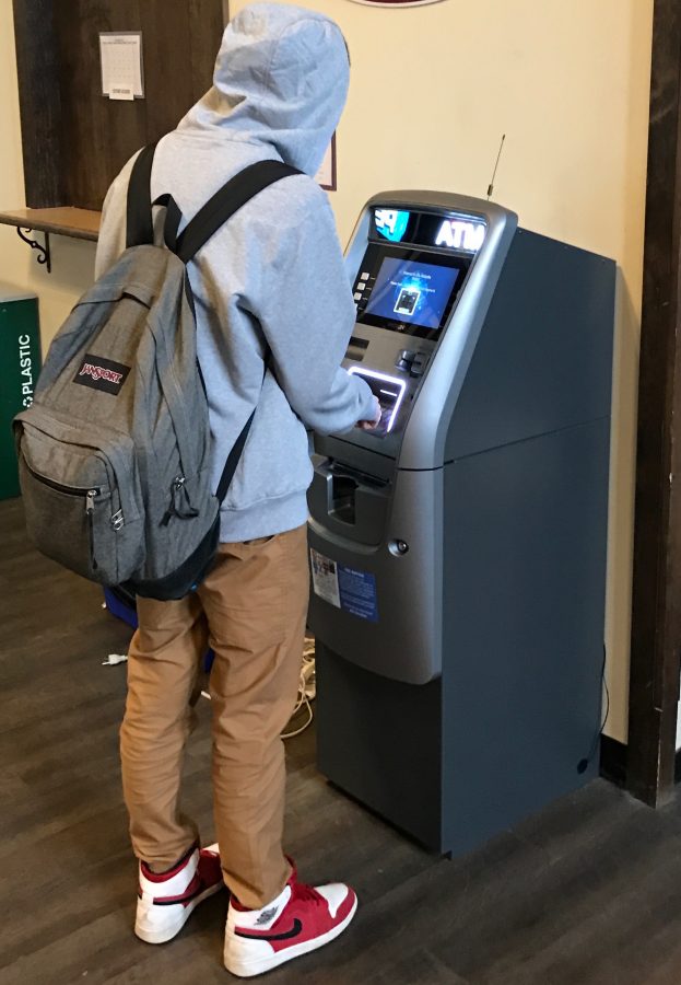 No cash? No problem. A student makes use of the ATM in the student center.
