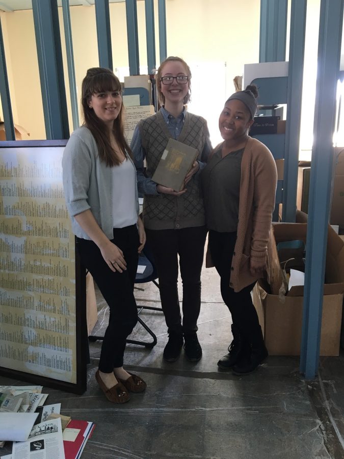 (From left) Eleanor Springer, Renee Pelletier, and Miesha Moss pose in the stacks, where the Mount Holyoke students are researching MacDuffie history. Photo by Alexis Chapin.