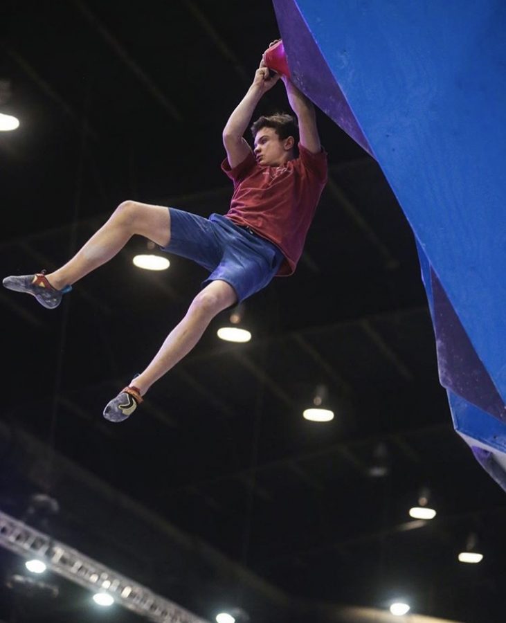 Squire dangles from a hold on one of the bouldering routes at the national competition. Photo provided by Brian Squire